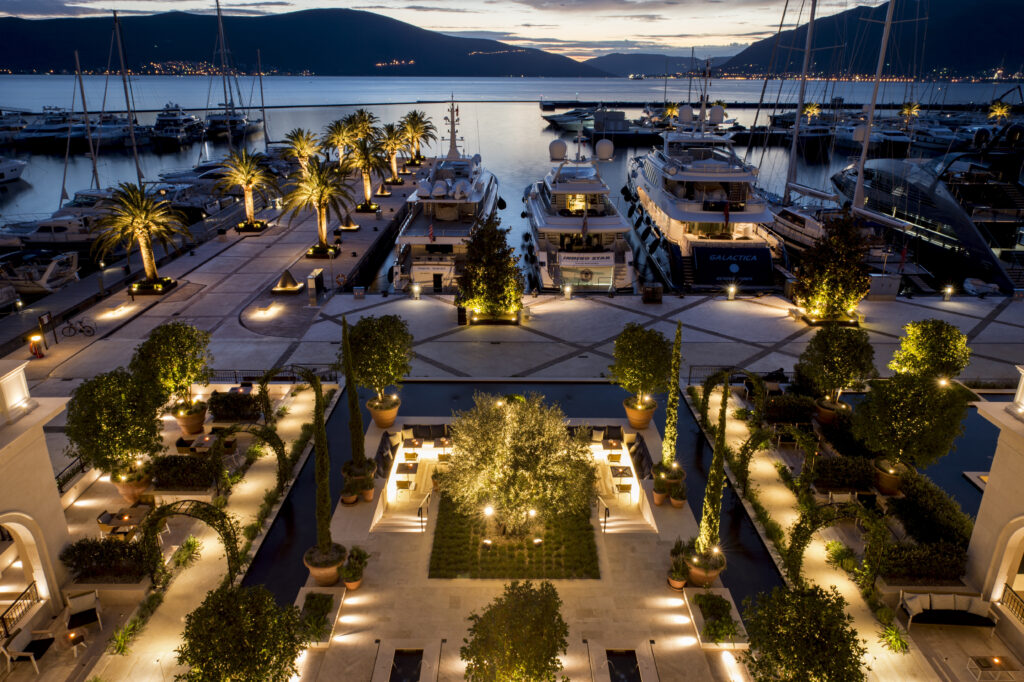 Night view over Porto Montenegro marina with illuminated palms and yachts beside Regent Porto Montenegro.