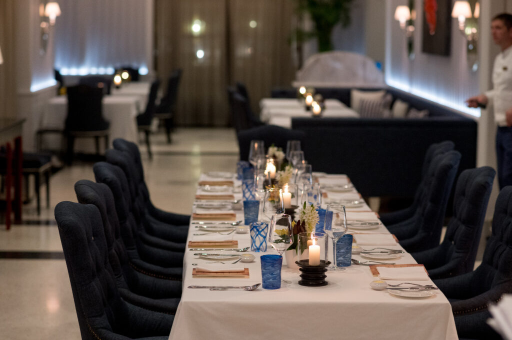 Candlelit long-table dinner setup inside Murano Restaurant at Regent Porto Montenegro.