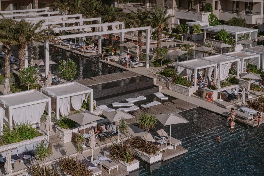 Pool club with cabanas, palms and sun loungers at Regent Porto Montenegro in Porto Montenegro marina.