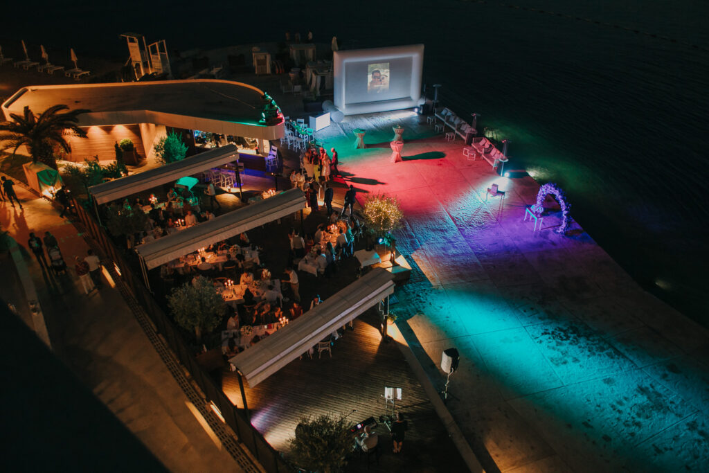 Night-time wedding celebration on the waterfront terrace at La Roche Hotel in Tivat, Montenegro, with lighting and open-air setup.