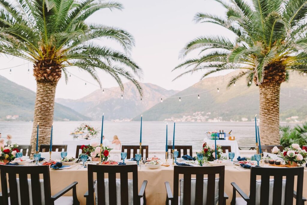 Wedding reception table styling with palms and sea view at Adriatica Restaurant & Beach Club, Montenegro.