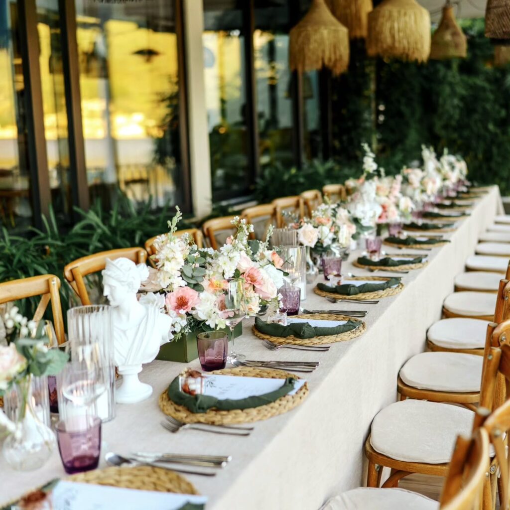 Long wedding dinner table with florals on the terrace at Bocasa Beach & Restaurant, Boka Bay, Montenegro.
