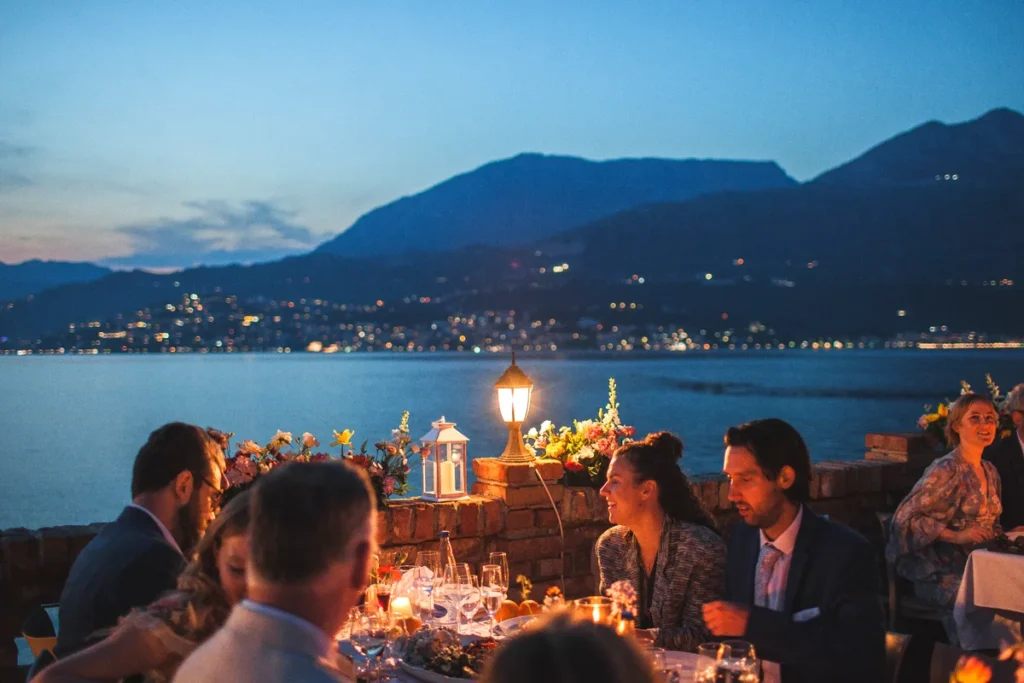 Long-table wedding dinner setup on a brick terrace overlooking Boka Bay at Forte Rose in Rose, Luštica Peninsula, Montenegro.