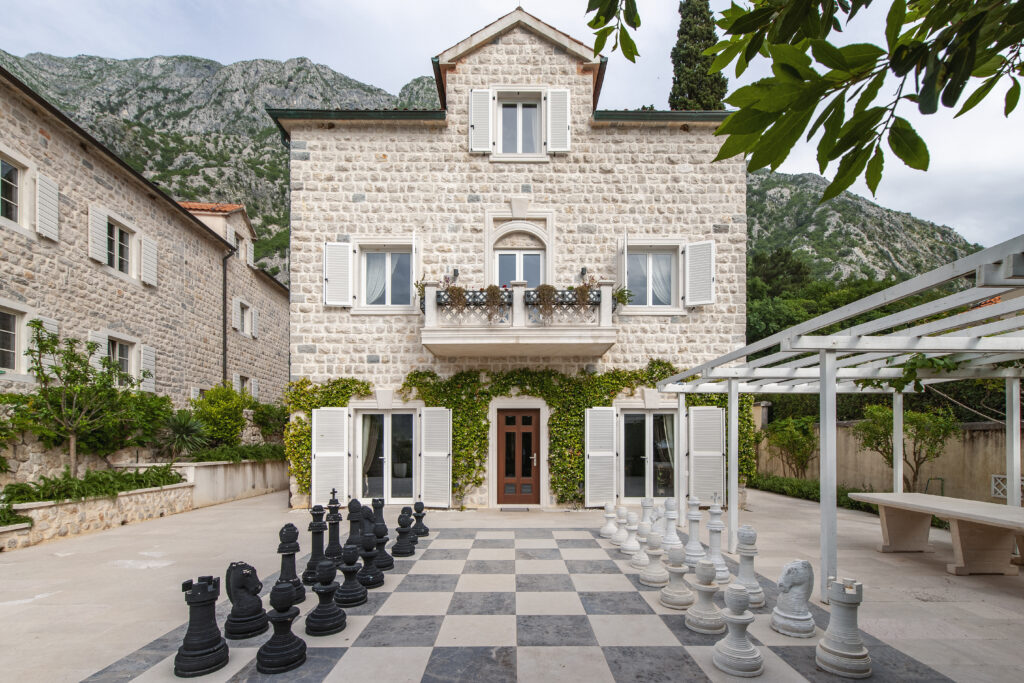 Stone villa courtyard with giant chess set at Villa Shah Montenegro