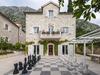 Stone villa courtyard with giant chess set at Villa Shah Montenegro