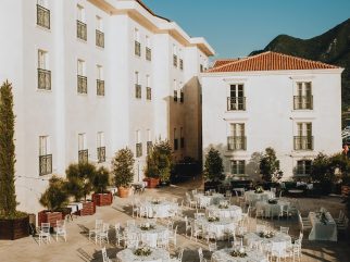 Courtyard wedding reception setup with round tables at Grand Heritage Perast, with mountains in the background.